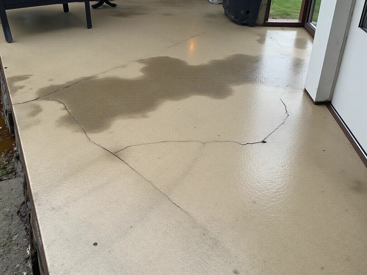 Cracked stained concrete patio with water damage before treatment